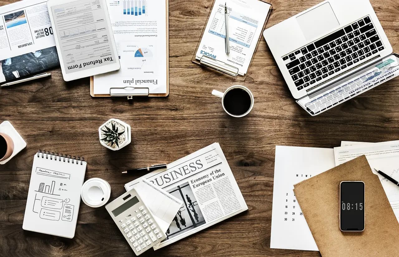Organized workspace with laptop, documents, and planning materials representing the streamlined social media workflow that 1Social provides