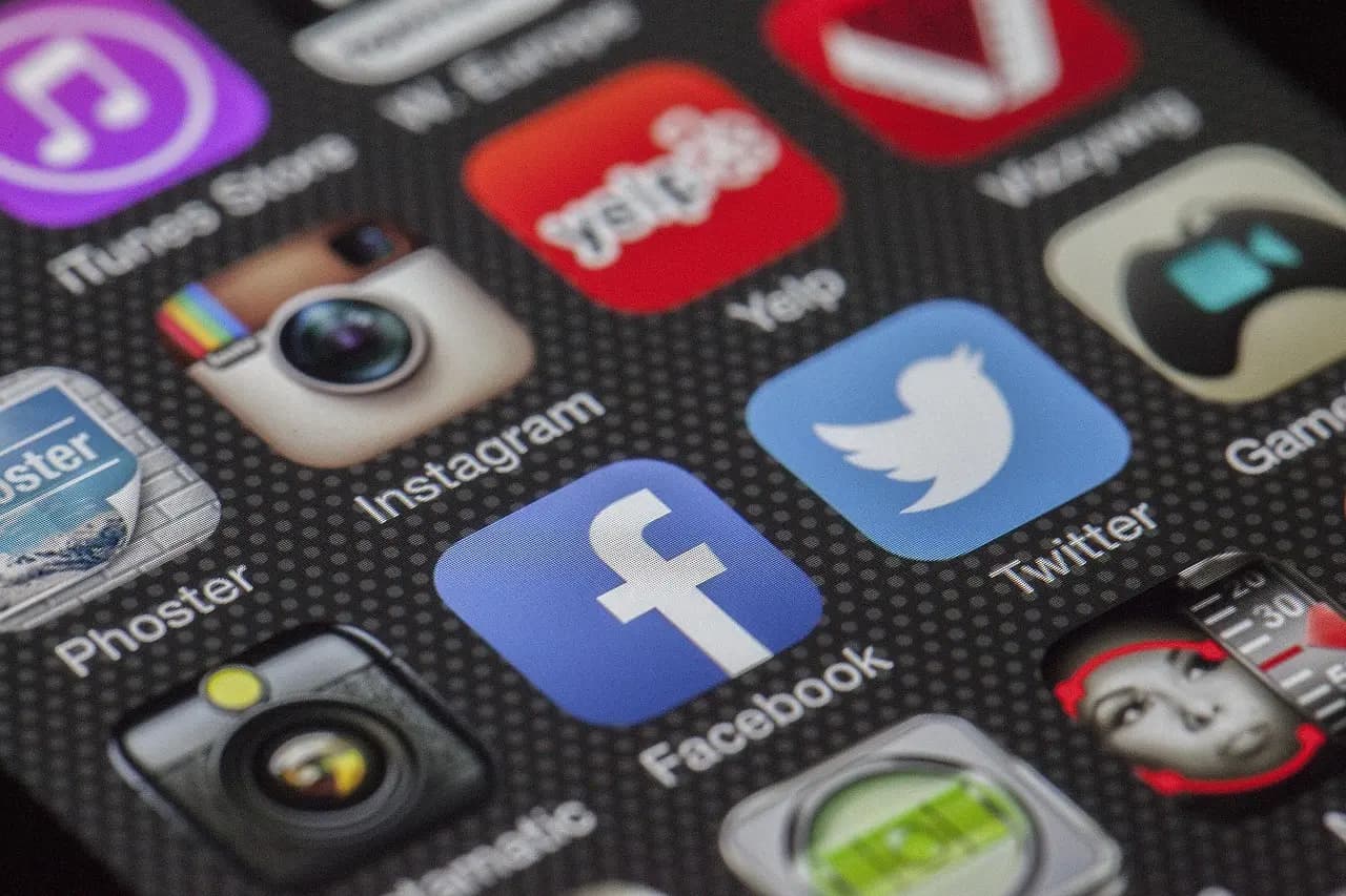 Close-up of smartphone showing social media platform apps including Facebook, Instagram, and Twitter that 1Social helps manage